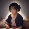 吾色平台主编张远的工作照，他正在专注审阅色彩文献资料，书架背景中陈列着大量色彩学专业书籍，气质沉稳、治学严谨